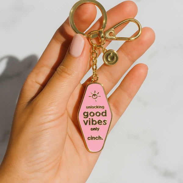 Good Vibes key ring by Cinch Skin styled on a modern vanity with skincare products—an aesthetic, minimalist accessory that adds a playful, positive touch to your everyday routine.